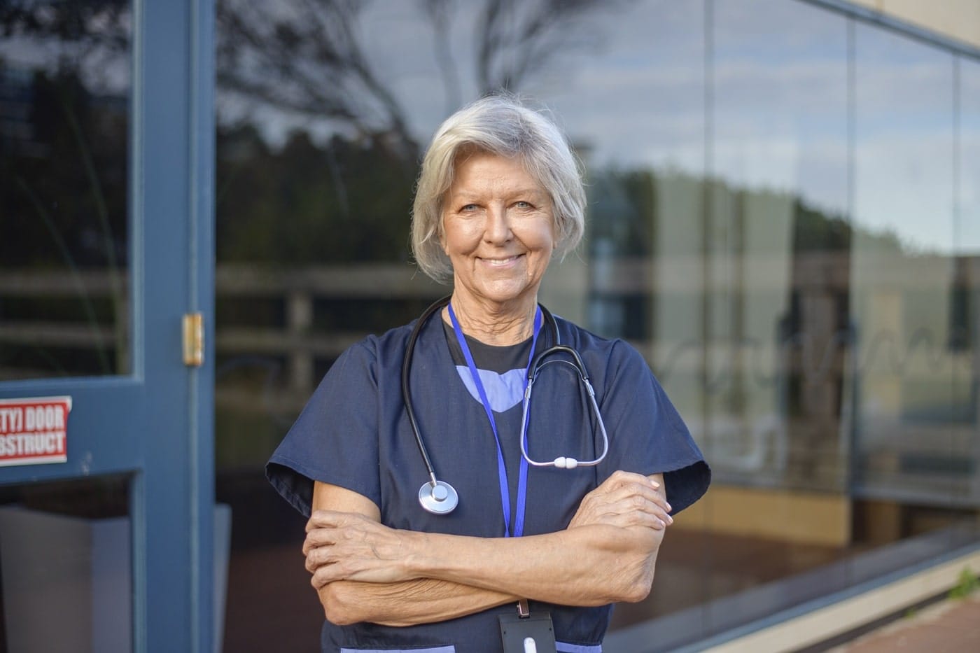 Female clinician posing confidently with stethoscope, symbolising healthcare leadership and trust in user-centered design.