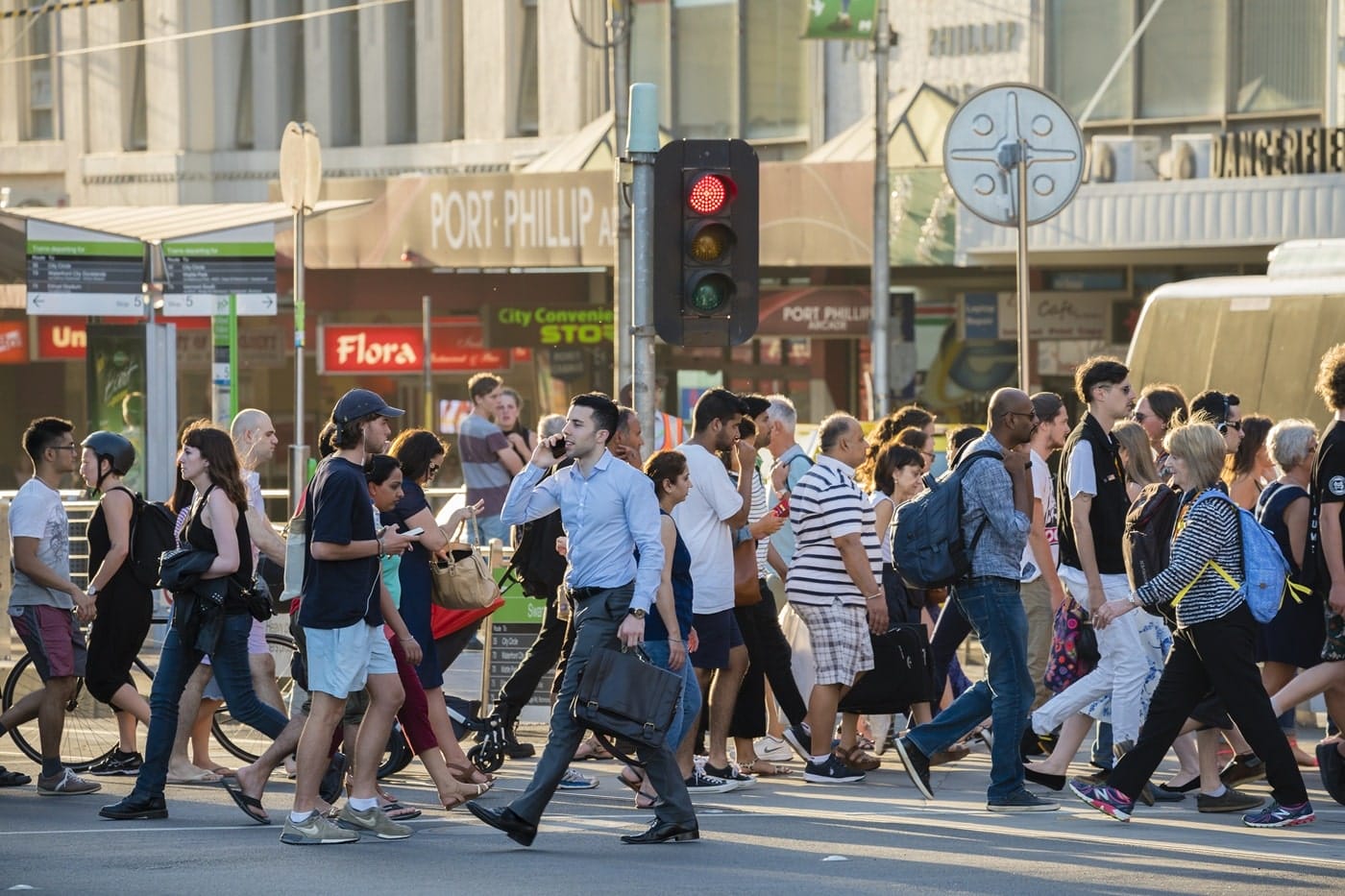 General public crossing busy street, illustrating regional engagement and diverse community movement.