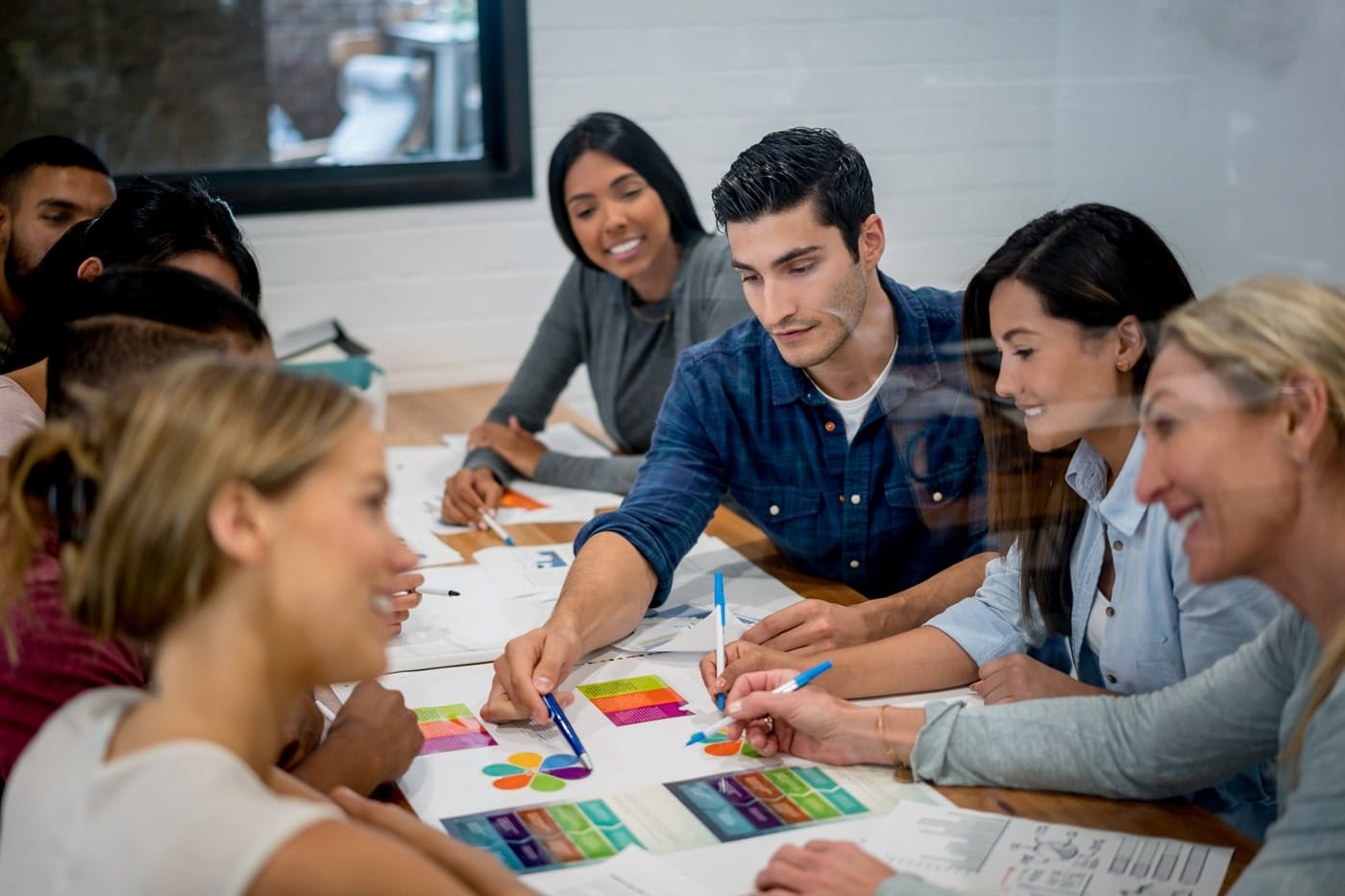 Team collaborating on graphics in boardroom, highlighting stakeholder collaboration and co-design processes.