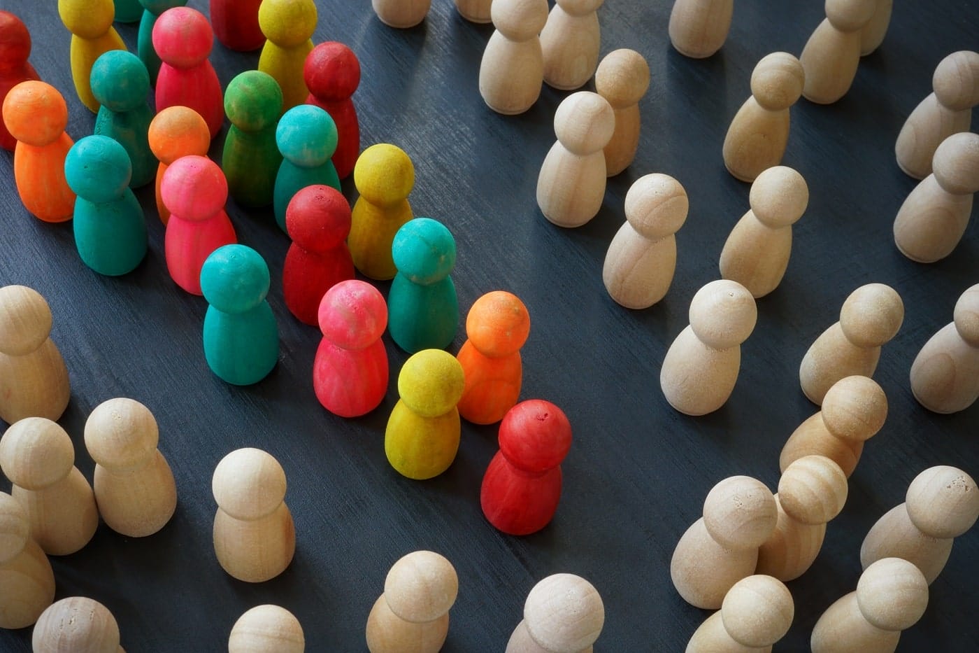 Wooden human figures in varied colors, representing diversity, inclusion, and community voices in participatory design.